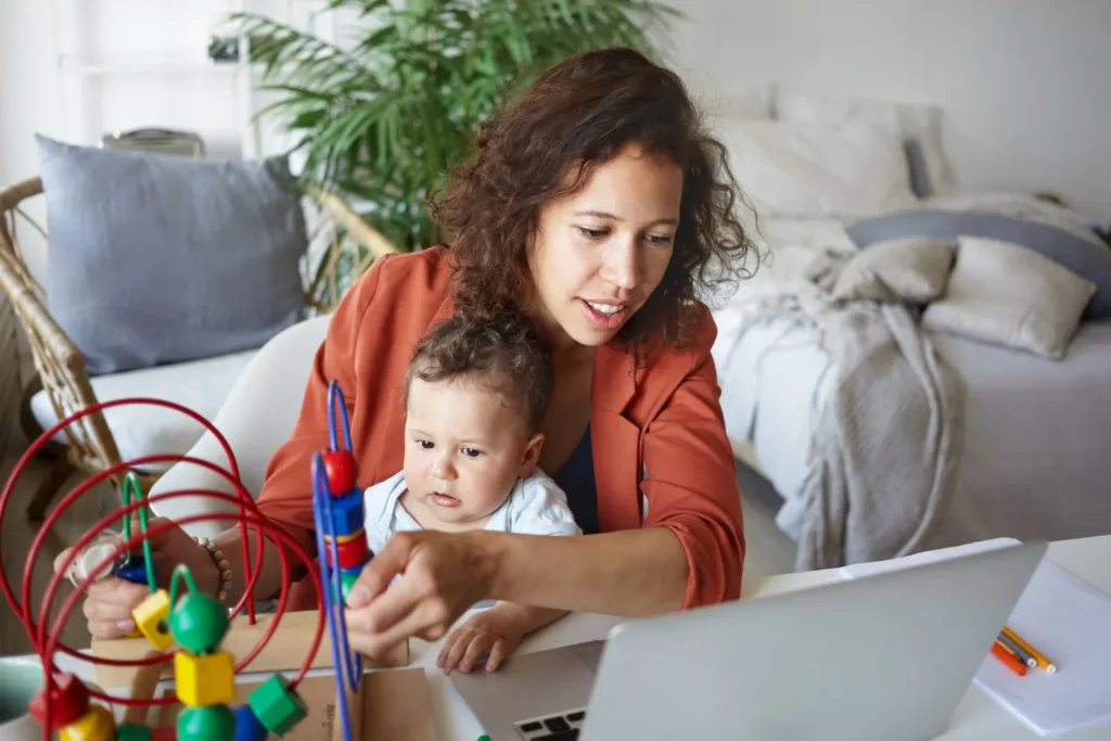 como equilibrar maternidade carreira e vida pessoal mae trabalha em casa com o bebe no colo usando n